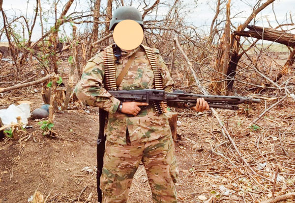 Боец группы «Вагнера» с трофейным MG-42/59 и лентами, на раздолбанном захваченном укрепрайоне противника. Покошенные артиллерией деревья - говорящая картина